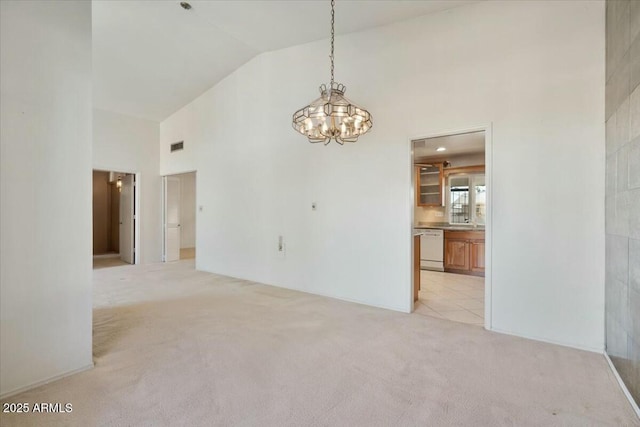 empty room with light carpet, visible vents, high vaulted ceiling, and a chandelier