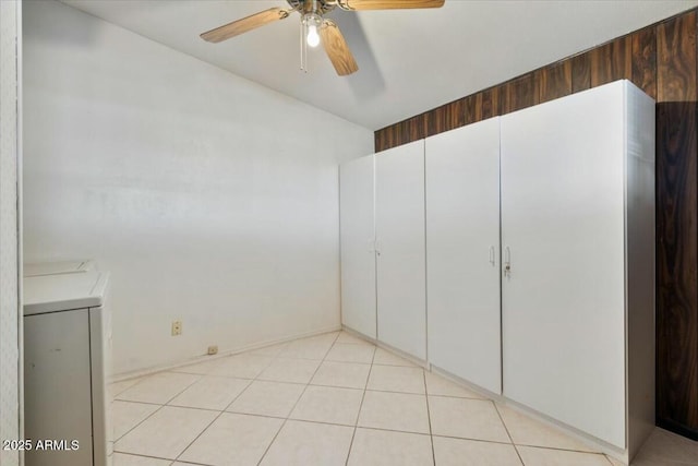 interior space featuring a ceiling fan, washing machine and clothes dryer, and light tile patterned floors