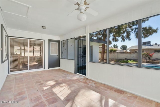 unfurnished sunroom featuring a ceiling fan