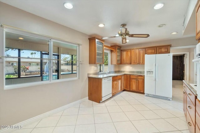 kitchen featuring light countertops, white appliances, recessed lighting, and brown cabinets