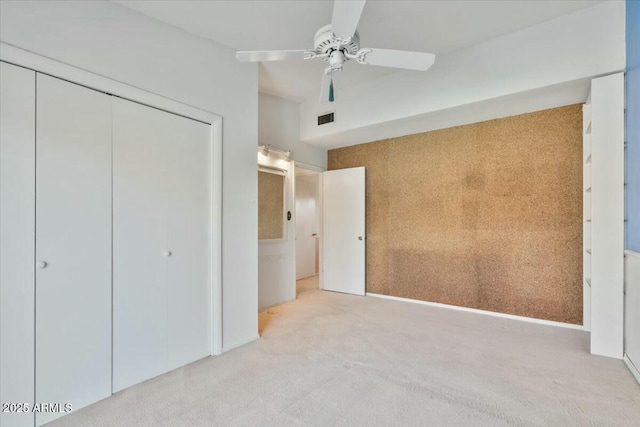 unfurnished bedroom with ceiling fan, a closet, visible vents, and light colored carpet