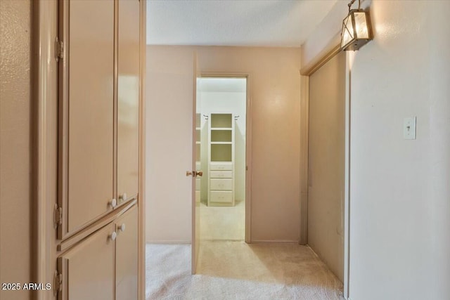 hallway with light colored carpet and a textured ceiling