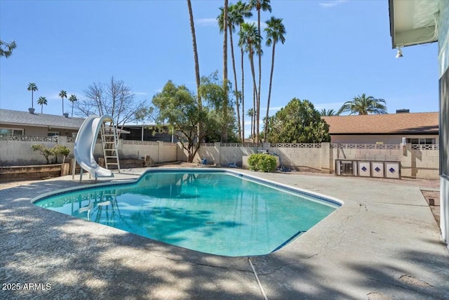 view of swimming pool with a patio area, a fenced backyard, a fenced in pool, and a water slide