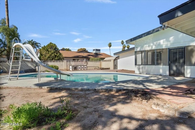 view of pool with a patio, a water slide, fence, and a fenced in pool