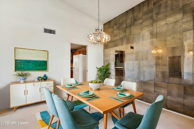 dining space with high vaulted ceiling, visible vents, a chandelier, and light colored carpet