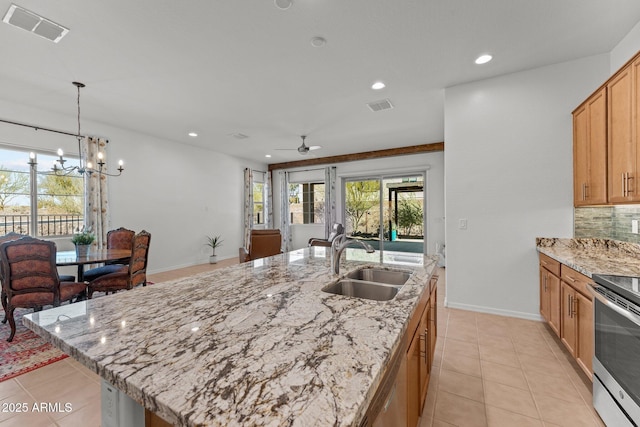 kitchen featuring stainless steel appliances, sink, a kitchen island with sink, and backsplash