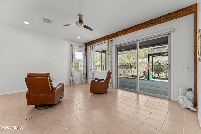 living area featuring light tile patterned floors and ceiling fan