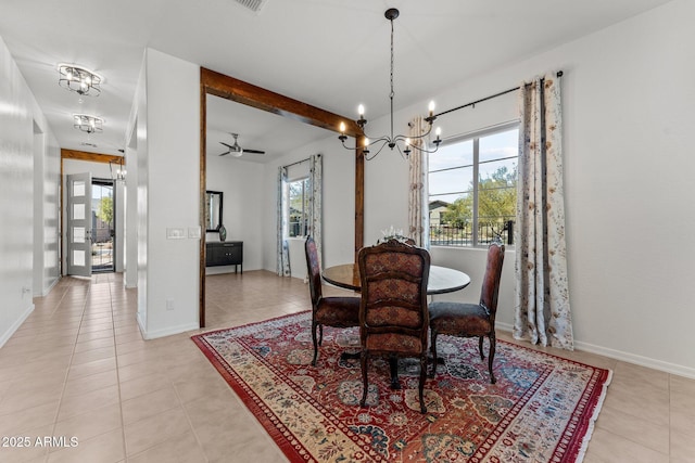 tiled dining area with ceiling fan with notable chandelier and a healthy amount of sunlight