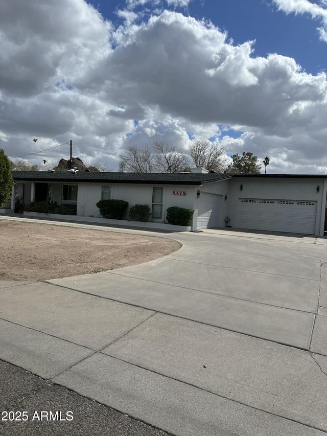 ranch-style home featuring a garage and concrete driveway