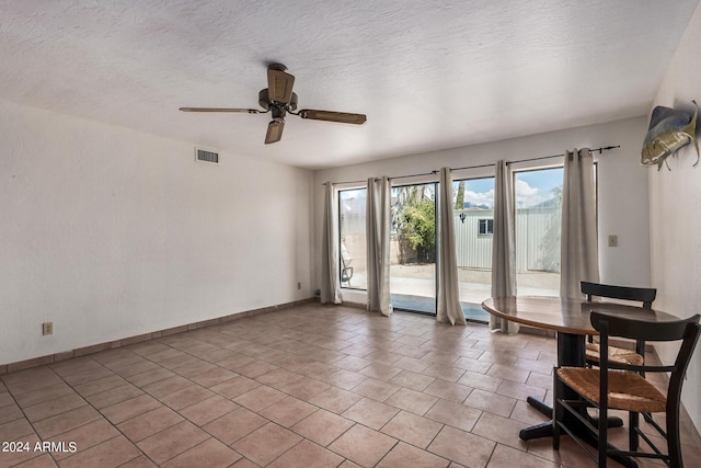 empty room featuring visible vents, a textured ceiling, baseboards, and light tile patterned flooring