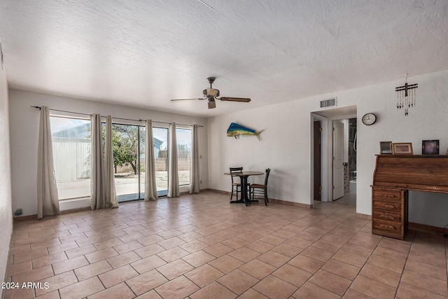 unfurnished living room with visible vents, light tile patterned flooring, ceiling fan, and a textured ceiling