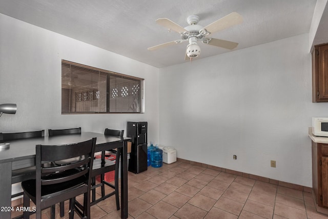 dining area with ceiling fan, light tile patterned floors, and baseboards