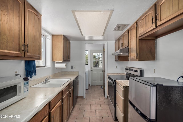 kitchen with stainless steel appliances, light countertops, visible vents, a sink, and under cabinet range hood