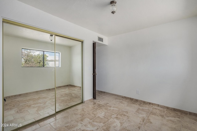 unfurnished bedroom with a closet and visible vents