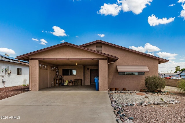 view of front of house featuring an attached carport, driveway, and stucco siding