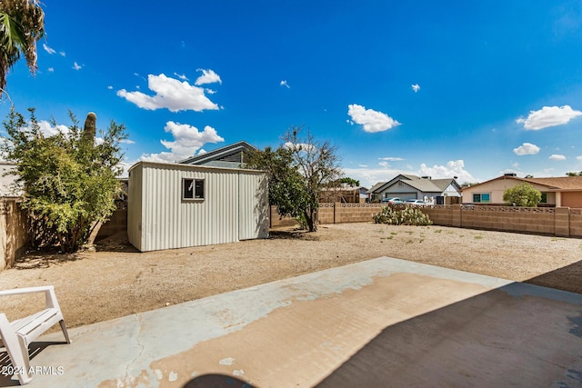 view of patio featuring an outbuilding, a shed, and a fenced backyard