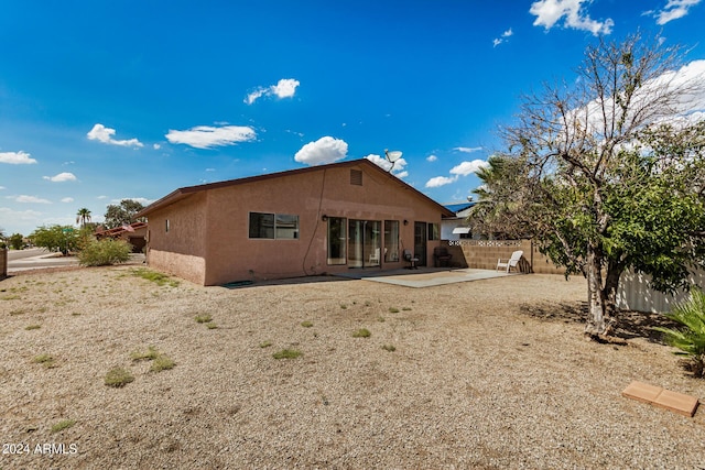 back of house featuring stucco siding, a patio, and fence