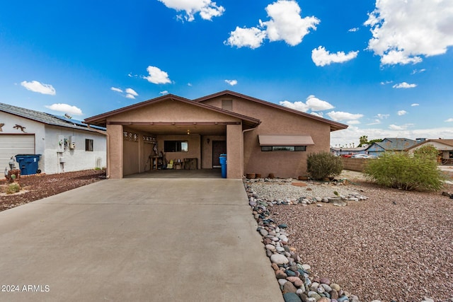 view of front facade featuring a carport, concrete driveway, and stucco siding