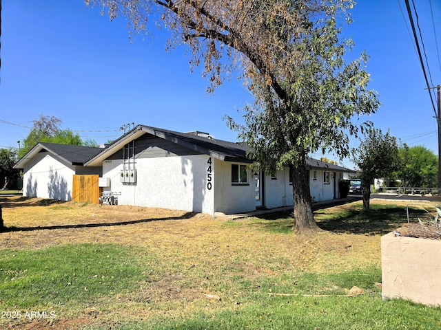4450 N Longview Ave, Phoenix, AZ 85014 - view of property exterior featuring stucco siding and a lawn