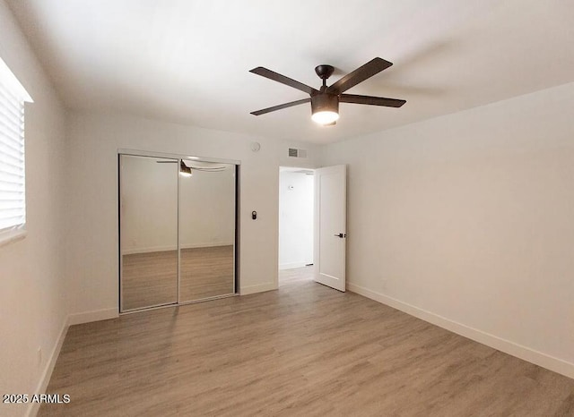 4450 N Longview Ave, Phoenix, AZ 85014 - unfurnished bedroom featuring light wood-style flooring, a closet, baseboards, and a ceiling fan