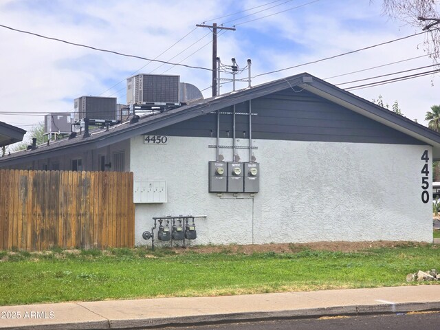 4450 N Longview Ave, Phoenix, AZ 85014 - view of side of property featuring central AC, stucco siding, and fence