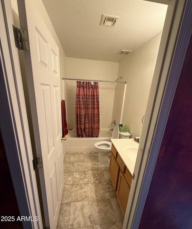 full bath with a textured ceiling, shower / tub combo, vanity, and visible vents