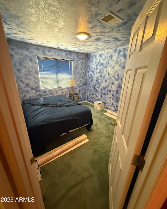 bedroom featuring wallpapered walls, a textured ceiling, visible vents, and carpet flooring