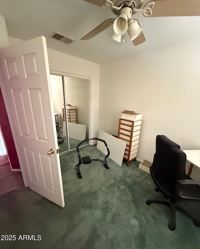 office space with a ceiling fan, carpet flooring, and visible vents