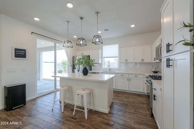 kitchen featuring visible vents, a sink, backsplash, appliances with stainless steel finishes, and white cabinets