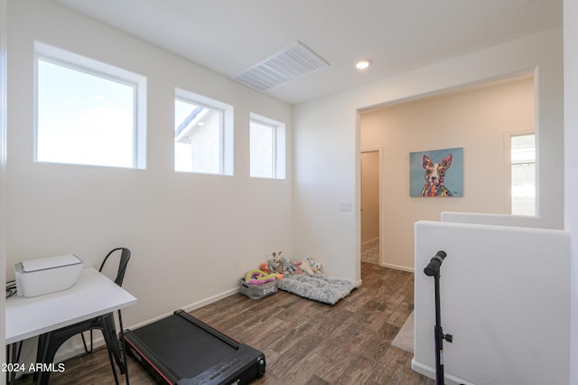 office area with wood finished floors, visible vents, and baseboards