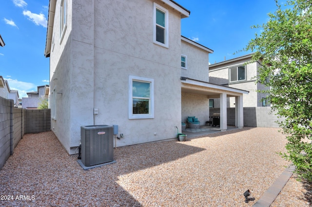 rear view of property featuring a patio area, central air condition unit, stucco siding, and a fenced backyard