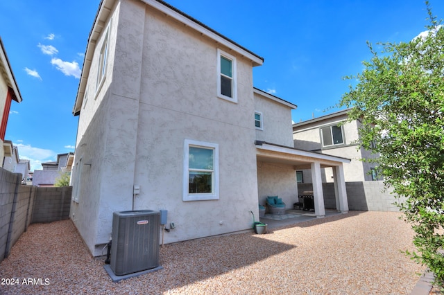 back of property with a patio area, central air condition unit, stucco siding, and a fenced backyard