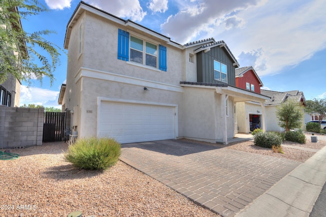 view of front of home featuring stucco siding, a gate, decorative driveway, fence, and a garage