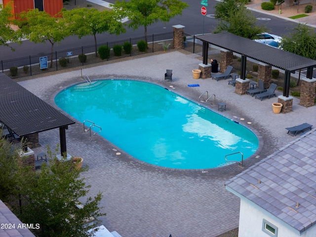 community pool featuring a patio area, a pergola, and fence