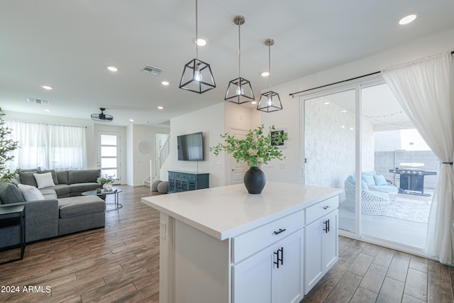 kitchen with white cabinets, visible vents, and wood finish floors