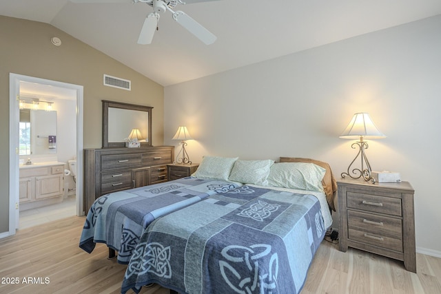 bedroom with ensuite bath, ceiling fan, light hardwood / wood-style flooring, and vaulted ceiling