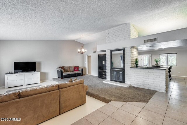 3102 W Betty Elyse Ln, Phoenix, AZ 85053 - living room with a chandelier, light tile patterned flooring, vaulted ceiling, a textured ceiling, and a fireplace