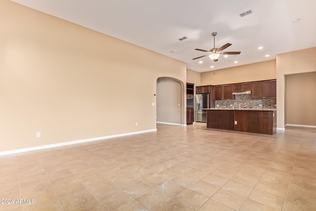 kitchen with ceiling fan, tasteful backsplash, stainless steel fridge with ice dispenser, a kitchen island with sink, and light tile patterned floors