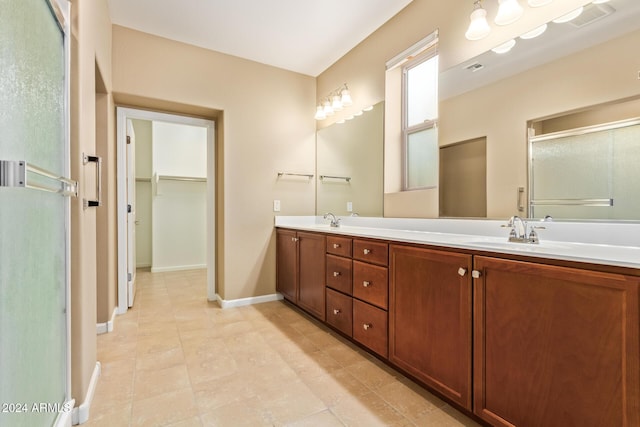 bathroom featuring tile patterned flooring, vanity, and a shower with door