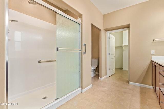 bathroom featuring vanity, toilet, and a shower with shower door