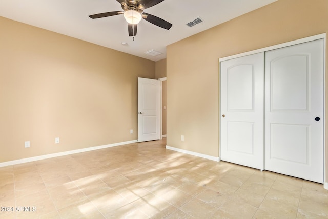 unfurnished bedroom with ceiling fan and a closet