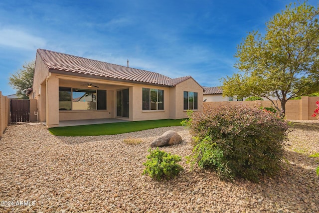 rear view of house with ceiling fan and a patio