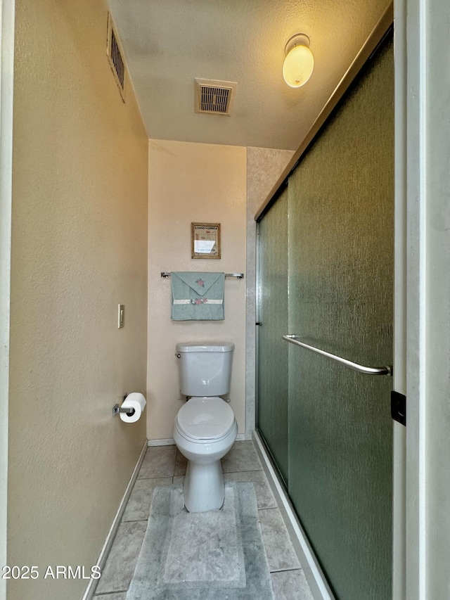 bathroom with baseboards, visible vents, a shower stall, and toilet