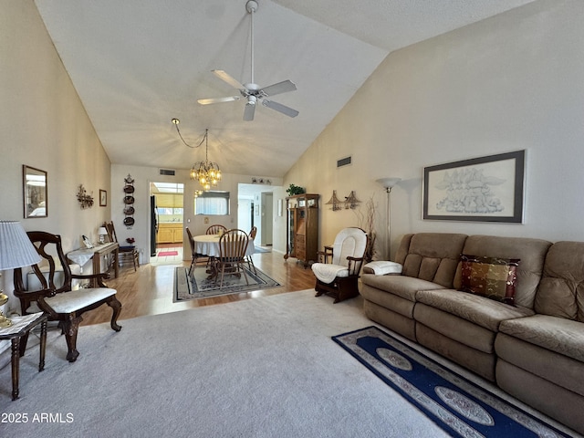 living area featuring visible vents, carpet flooring, wood finished floors, high vaulted ceiling, and ceiling fan with notable chandelier