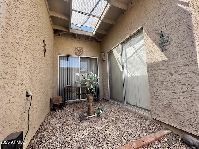 doorway to property featuring stucco siding