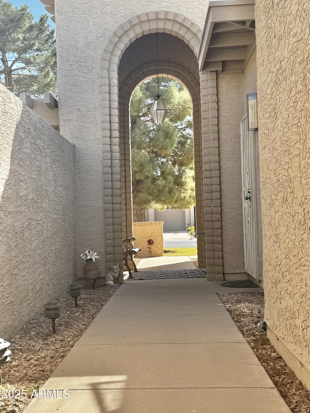 view of exterior entry featuring fence and stucco siding