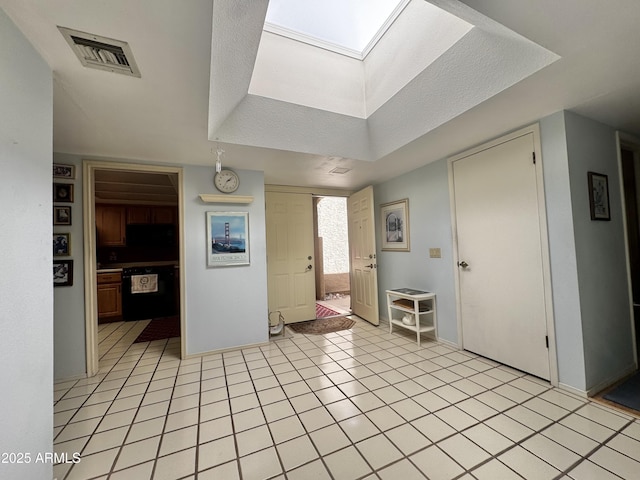 entrance foyer with light tile patterned floors, a skylight, visible vents, and baseboards