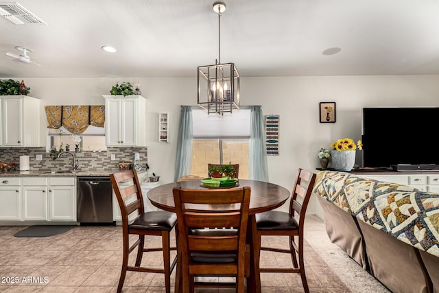 tiled dining area featuring sink and a chandelier