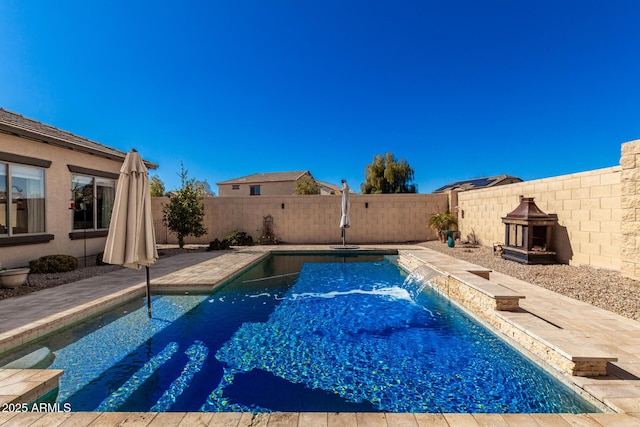 view of swimming pool featuring pool water feature and a patio