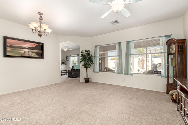 carpeted empty room with ceiling fan with notable chandelier